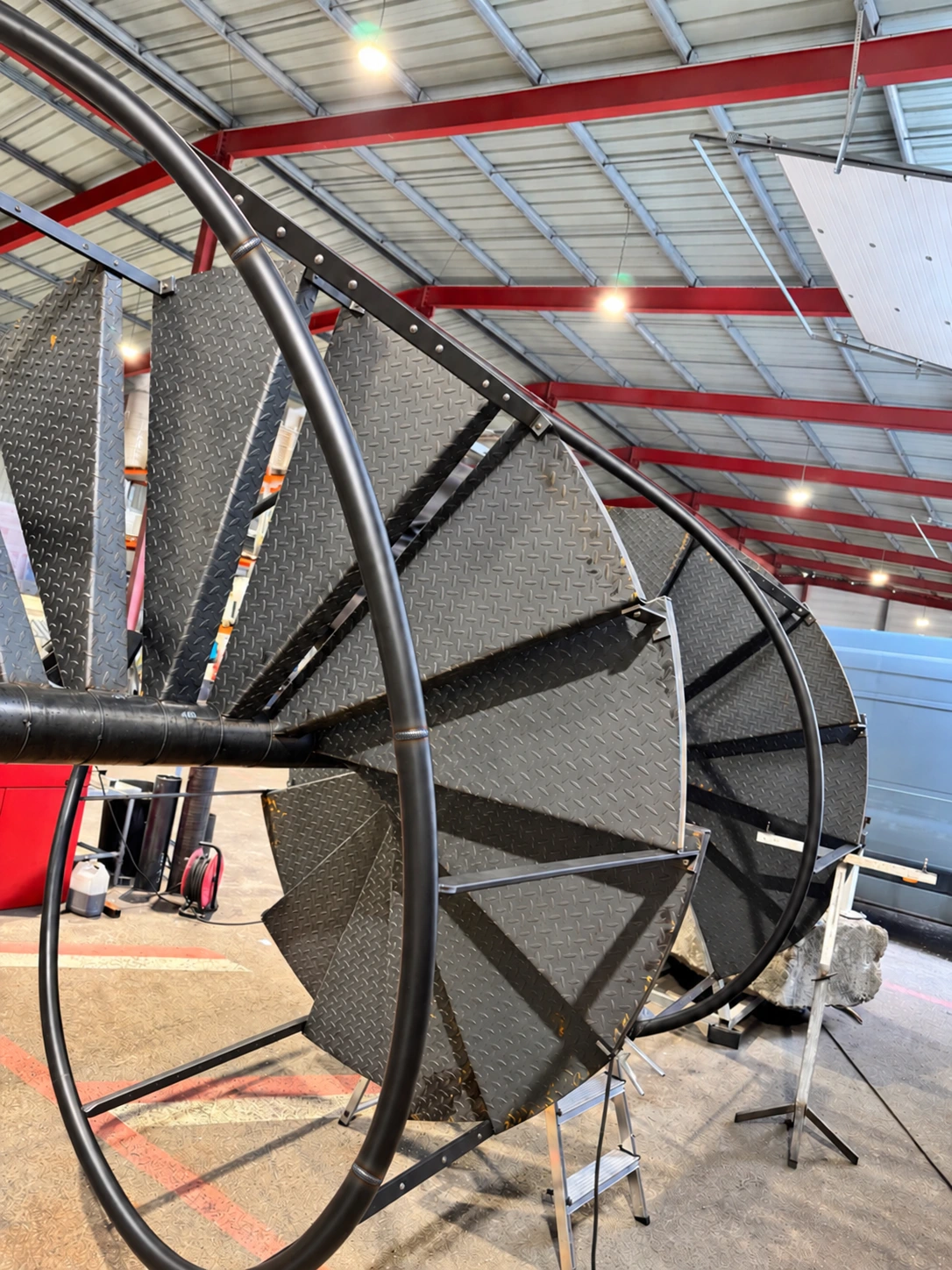Escalier hélicoïdal en cours de fabrication dans l'atelier LTS, avec soudures aux raccords de la main courante cintrée